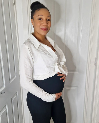 Woman wearing  Black maternity leggings. Looking happy with a pregnancy glow